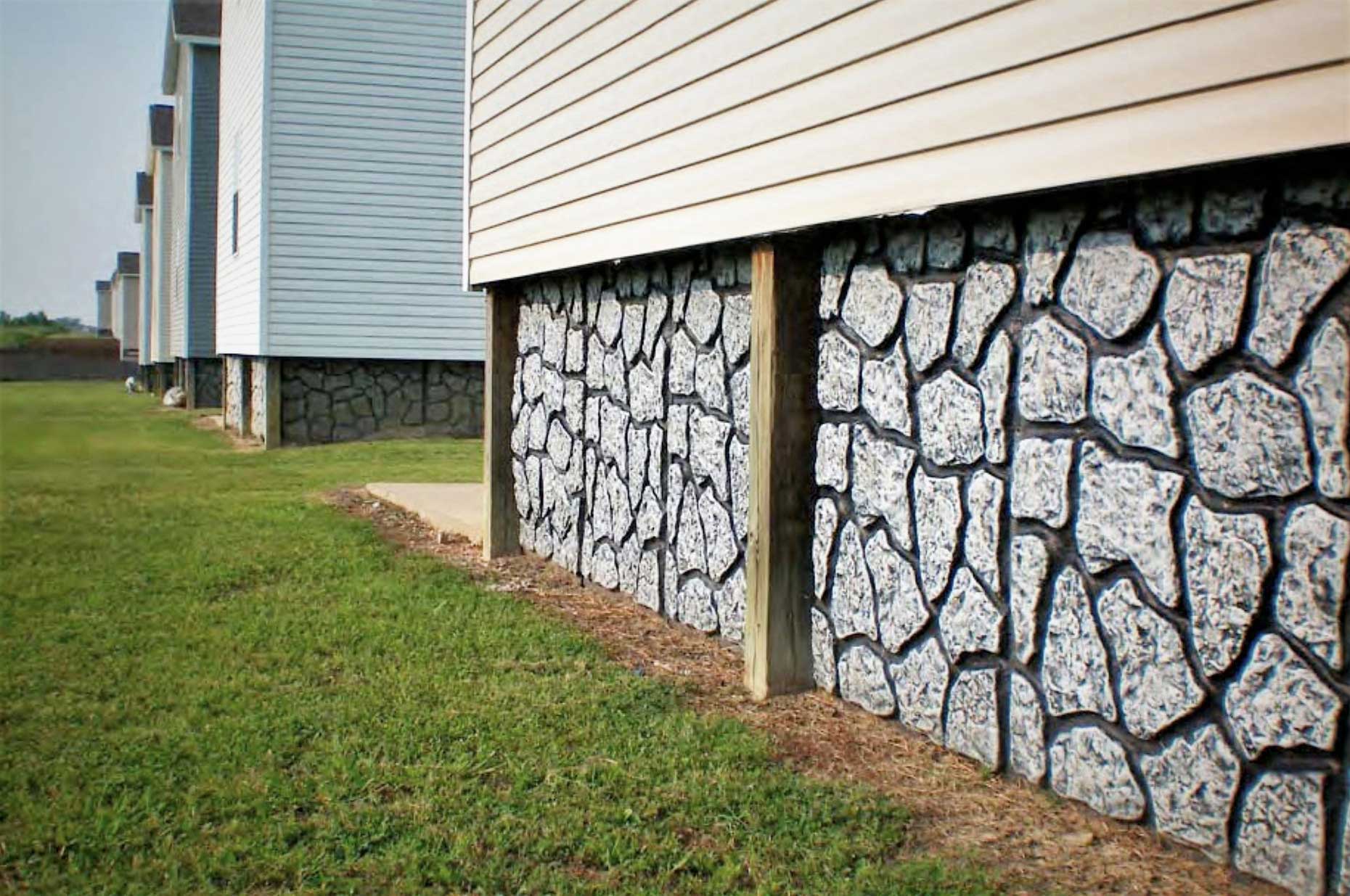 close up of rock wall acting as skirt around home