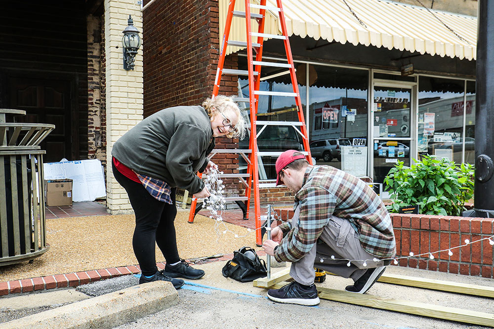 Shelby Jaco, left, and Rayce Belton work on a light project for the alley